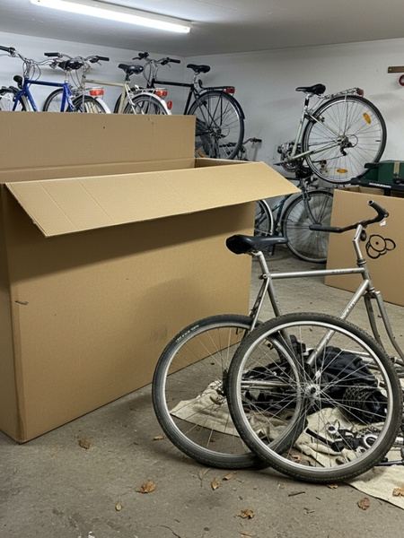Fahrradkarton in Keller neben Fahrradteilen